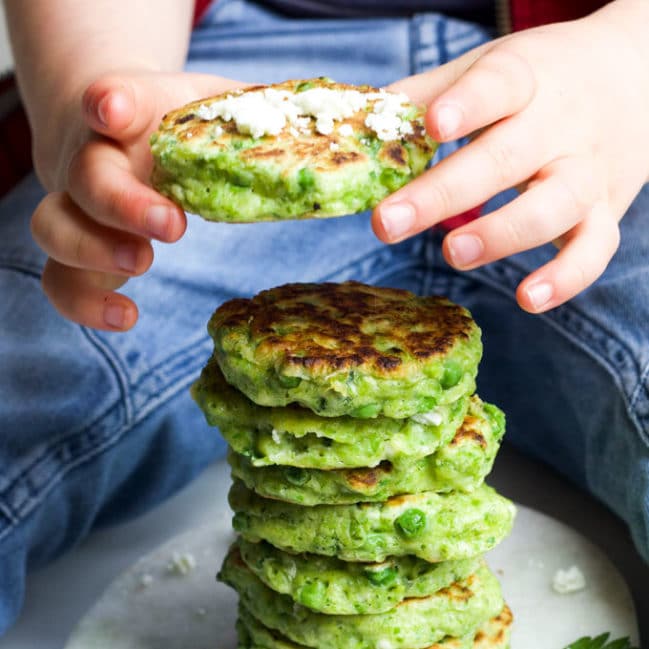 Child Grabbing a Pea Fritter from a Stack