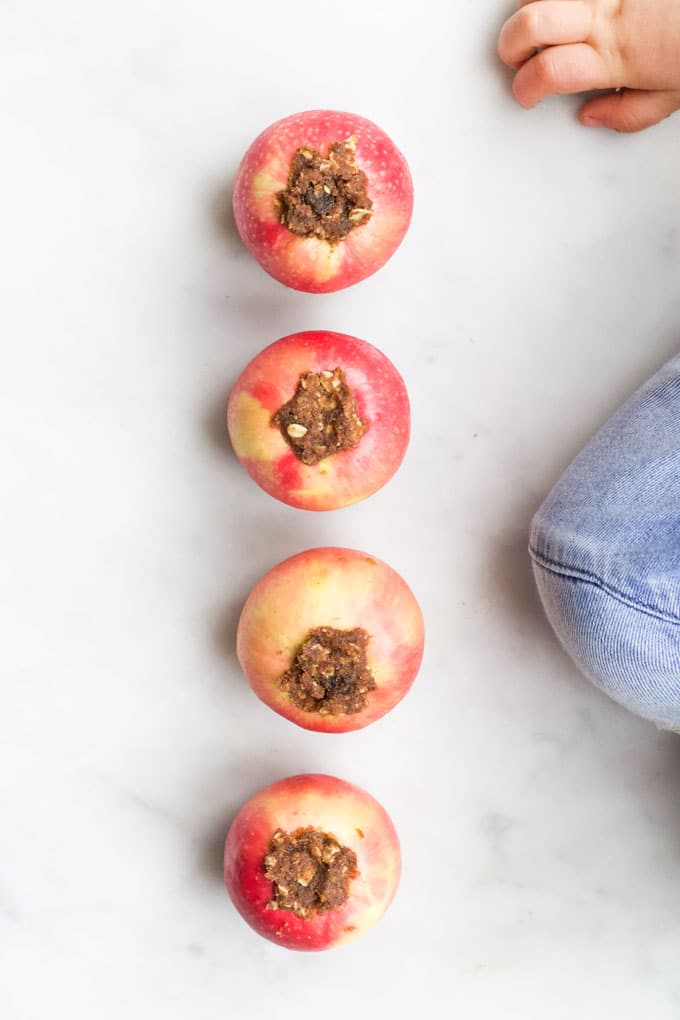 Child Sitting Next To Pre Cooked Baked Apples After Filling Them