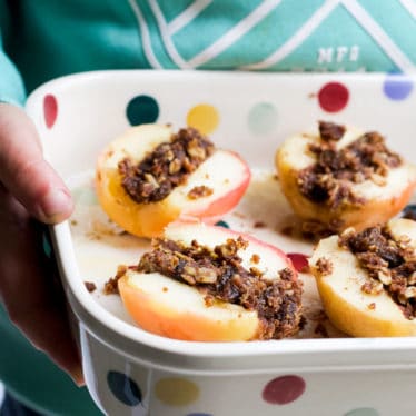 Child Holding Dish of Baked Apples Cut in Half