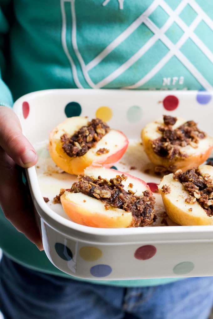 Child Holding Dish of Baked Apples Cut in Half