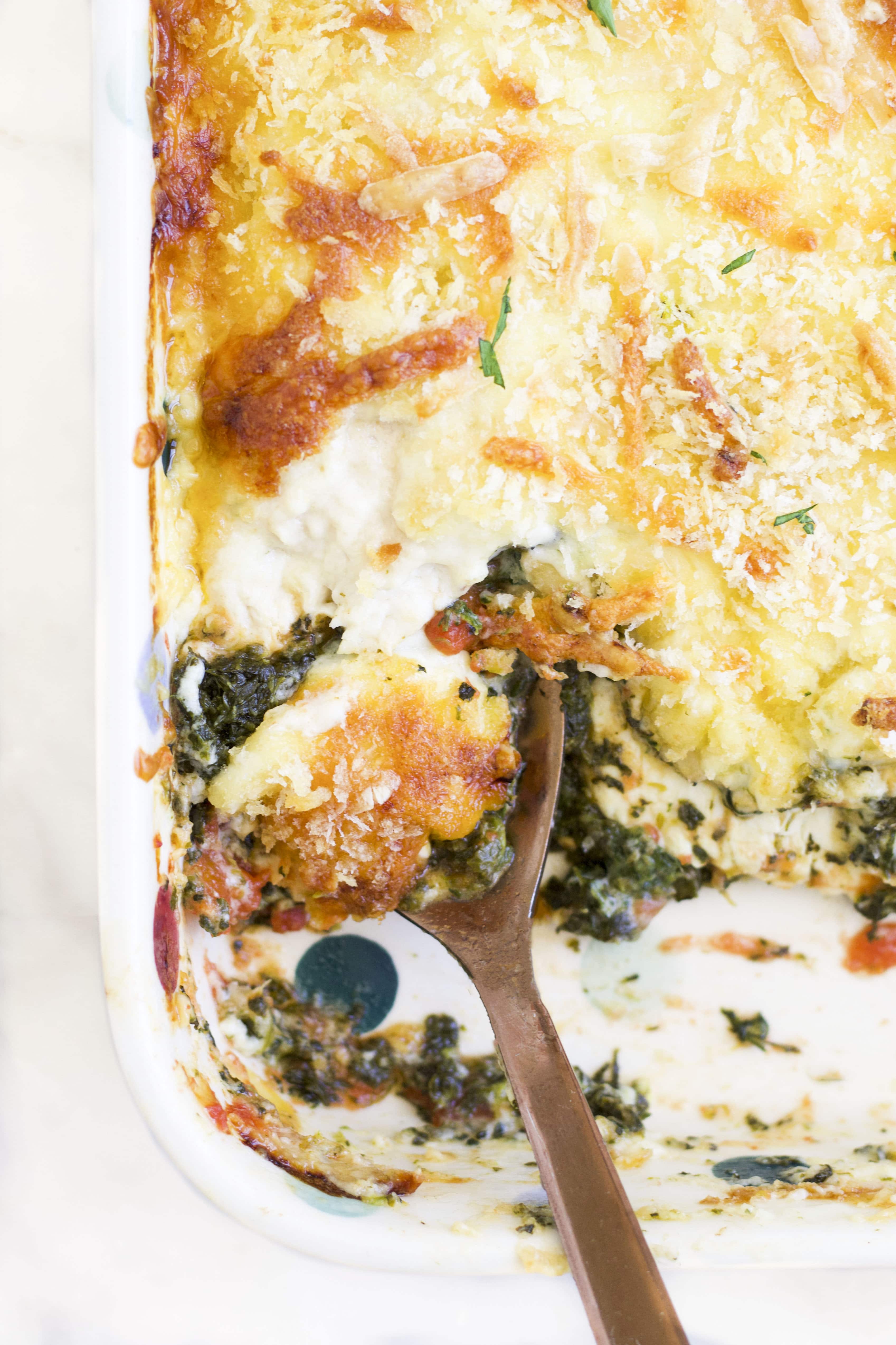 Close Up of Baked Chicken Florentine in Baking Dish with Portion Removed