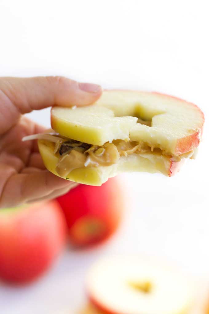 Child Holding Apple and Peanut Butter Sandwich with Bite Out