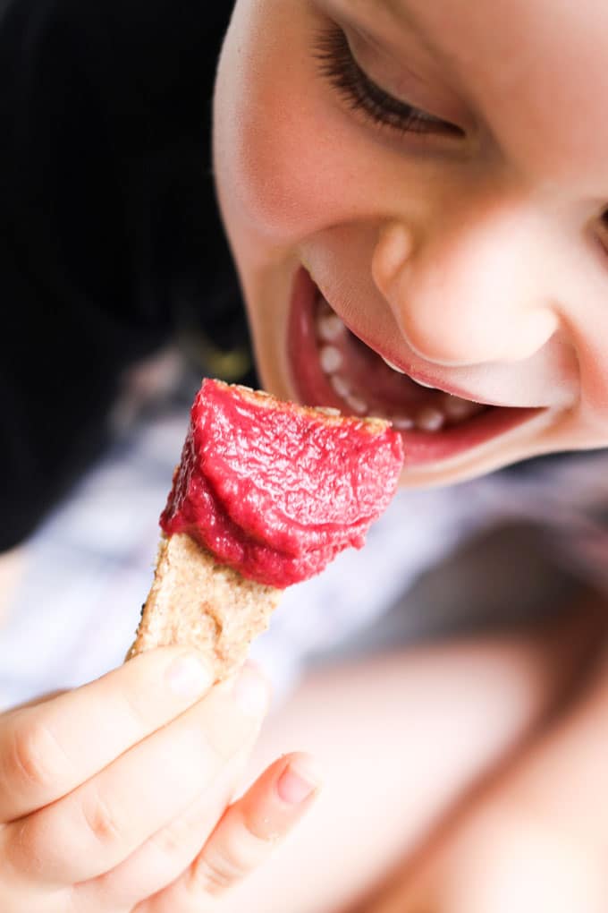 Child Eating Beetroot Dip on Cracker