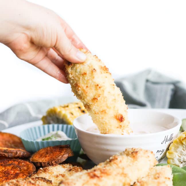 Hand Dipping Coconut Chicken Tender into Dip