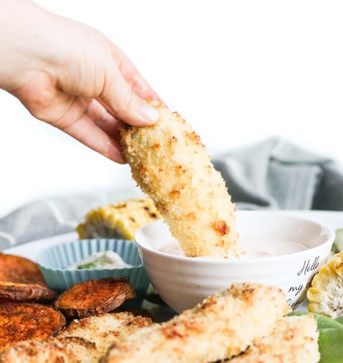 Hand Dipping Coconut Chicken Tender into Dip