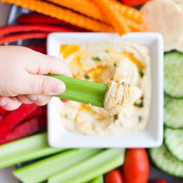 Kid Dipping Celery into Hummus