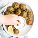Child Dipping Spiced Meatball in Mint Yogurt Sauce