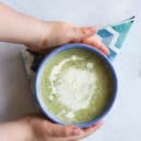 Child Grabbing Bowl of Courgette Soup (Zucchini)