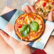 Toddler Hands Holding Cauliflower Pizza.