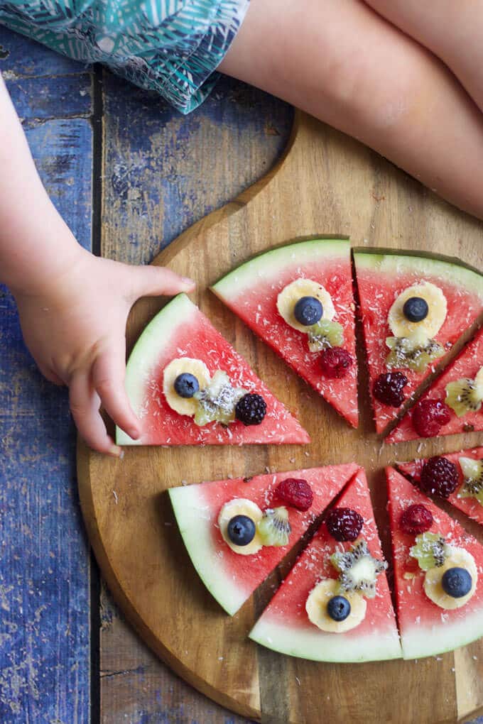 watermelon pizza is a refreshing, fun and healthy snack / dessert for kids. Let kids choose their toppings.
