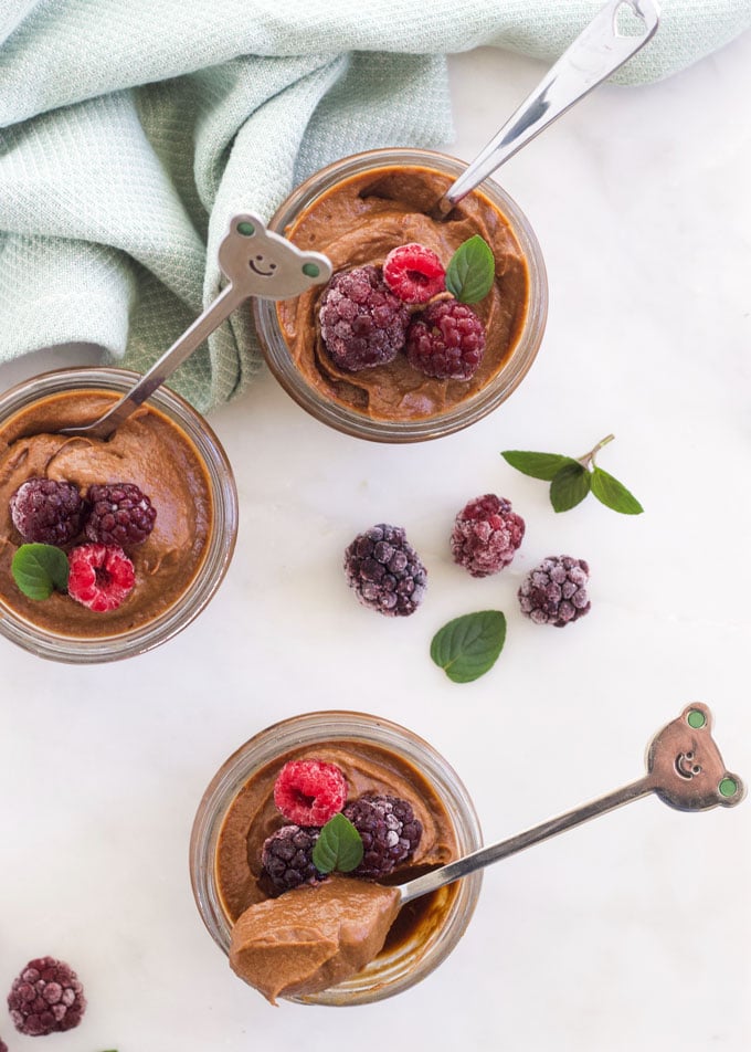 Three Small Pots of Avocado Mousse Topped with Berries.