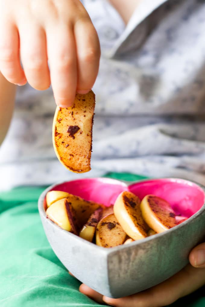 Child Taking an Apple Wedge from Bowl. 