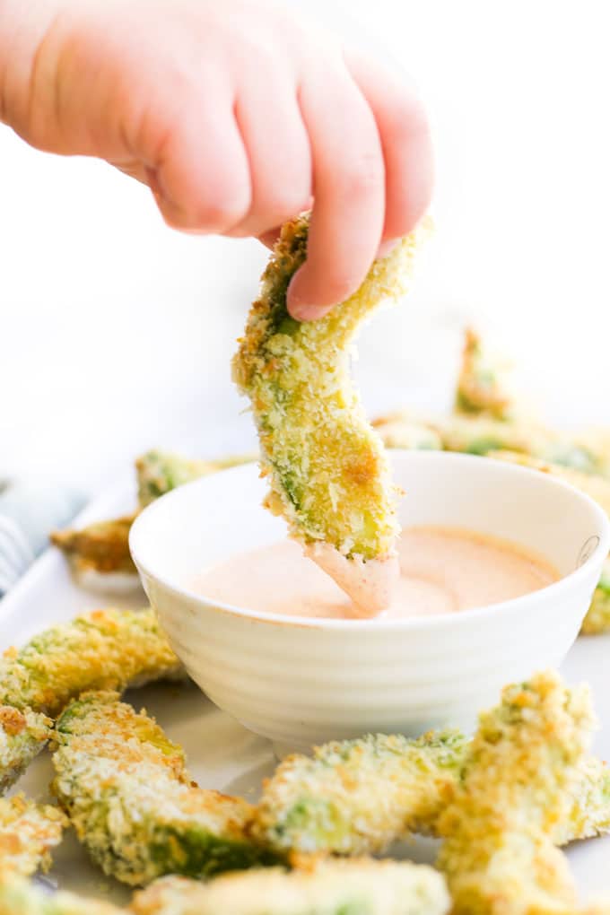 Child Dipping Avocado Fries into a Dip