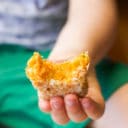 Child Holding Sweet Potato Croquette with Bite Out