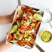 Child's Hands Holding Tray of Loaded Chili Cheese Sweet Potato Fries.