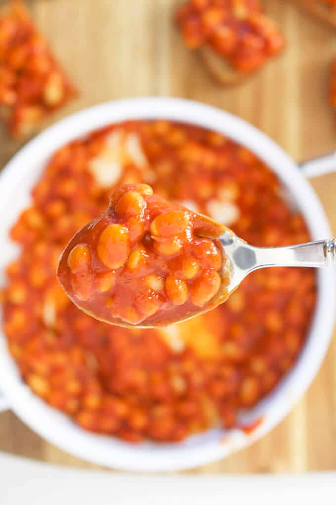 Spoon of Baked Beans Held over a Pan