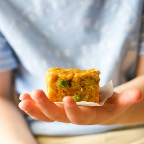 Child holding a slice of lentil bake