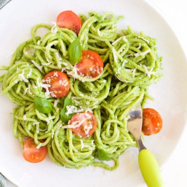 Plate of Avocado Spinach Spaghetti Topped with Cherry Tomato