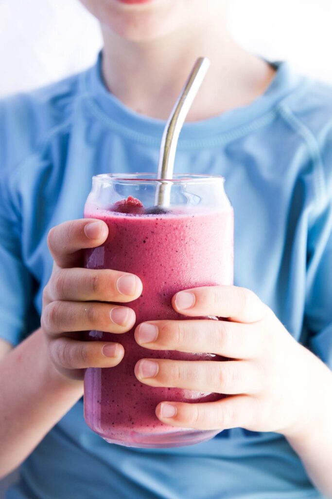 Child Holding Glass of Beet Smoothie