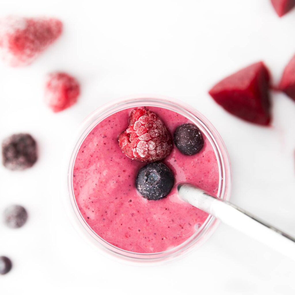 Top Down Shot of Beet Smoothie in a Glass Topped with Berries