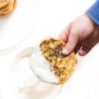 Child Dipping Lentil Pancake into Yoghurt Dip