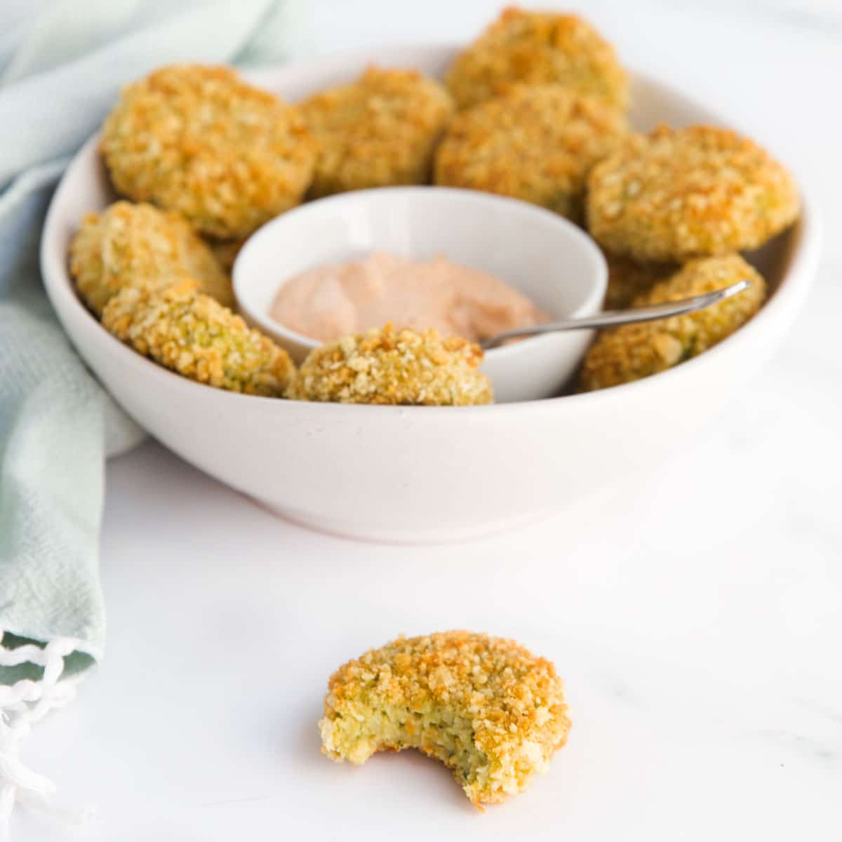 Veggie Nugget with Bite Removed in Foreground with Bowl of Veggie Nuggets in Background.