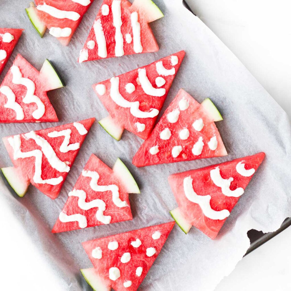 Watermelon Triangles Cut into Christmas Trees and Decorated with Yogurt