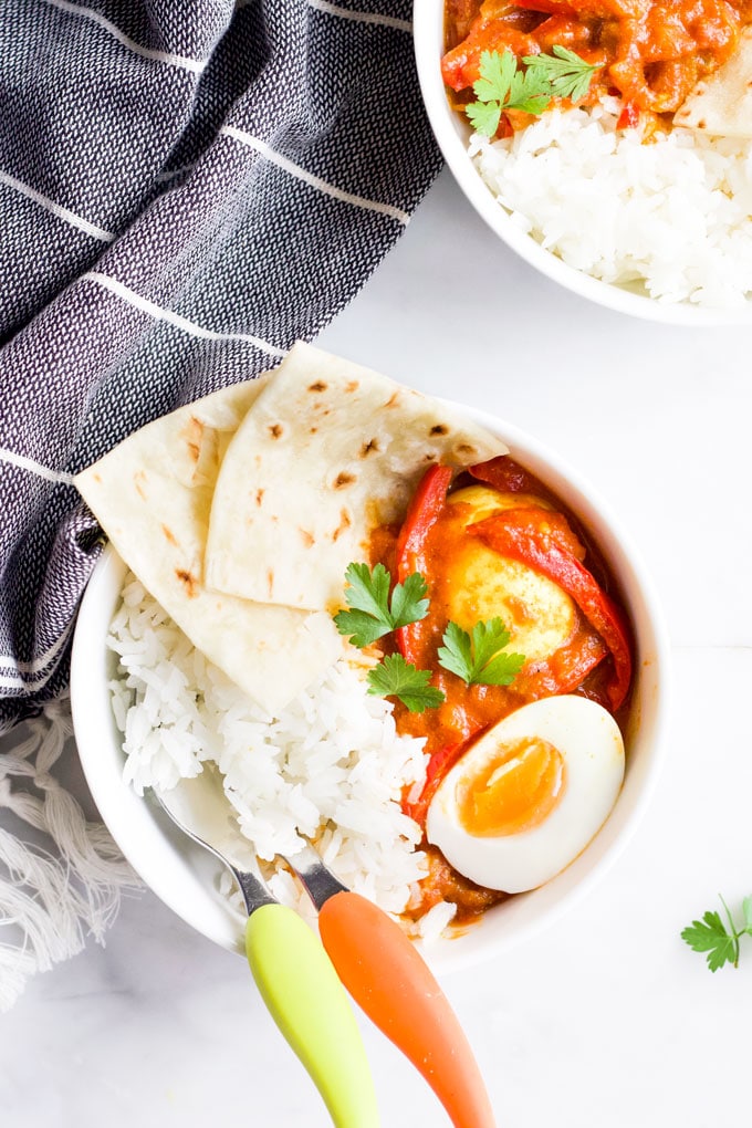 Bowl of Egg Curry Served with Rice and Roti Bread