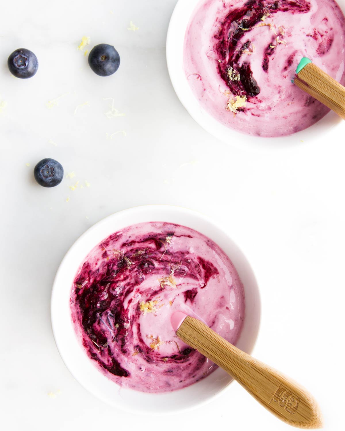 Two Small Bowls of Blueberry Yogurt with Blueberries Scattered