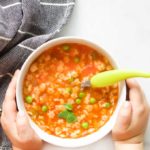 Child Holding a Bowl of Minestrone Soup