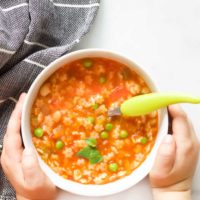 Child Holding a Bowl of Minestrone Soup