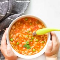 Child Holding a Bowl of Minestrone Soup