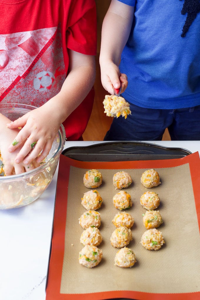 Making chicken meatballs. Children forming lemongrass and ginger chicken meatballs.