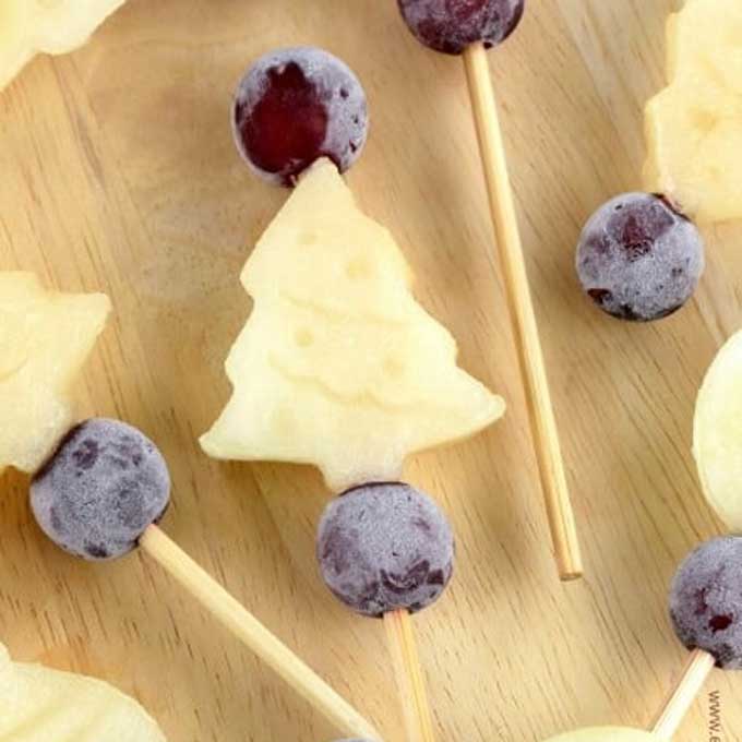 Pinchos navideños hechos con melón y uvas congelados