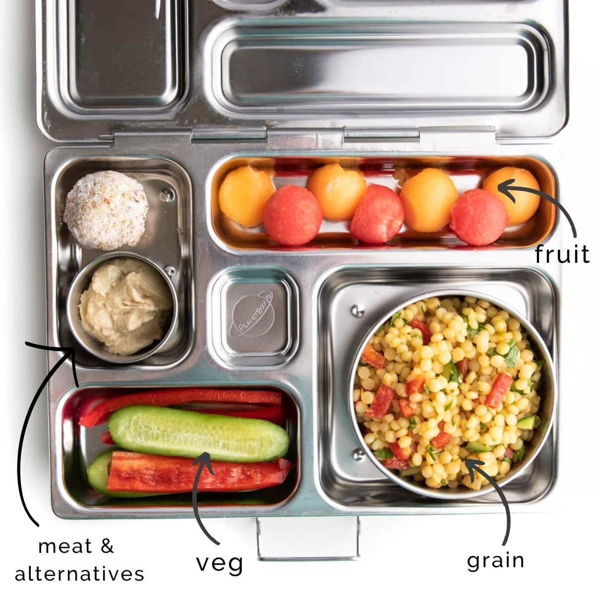 Metal Bento Lunchbox Packed with CousCous Salad, Melon Balls, Bell Pepper Stips, Cucumber, Hummus and a Oat Ball.