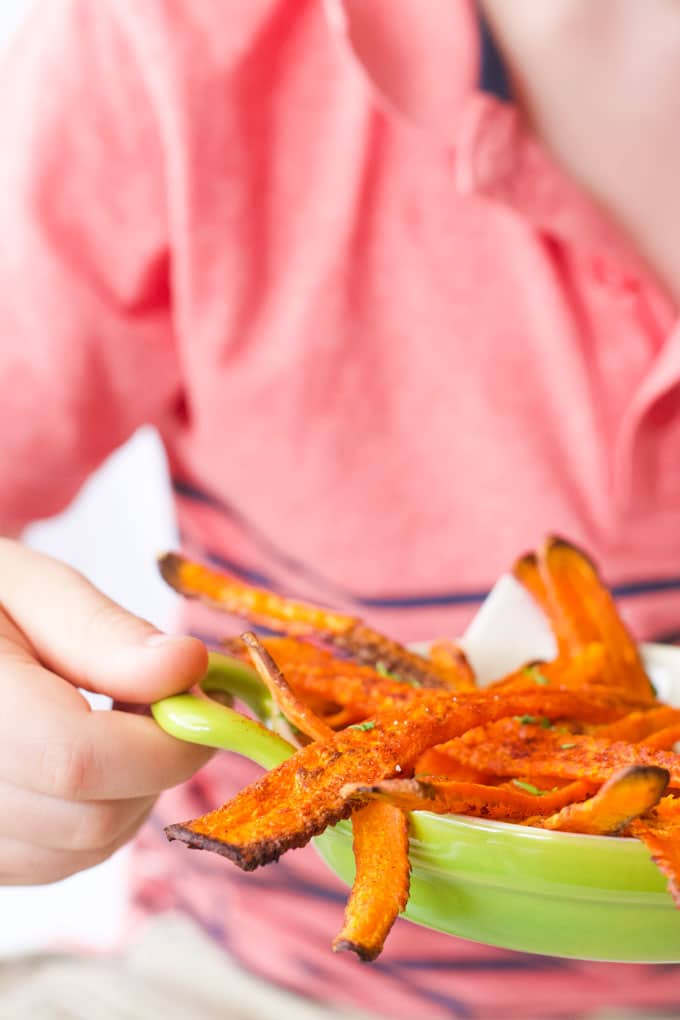 Child Holding Bowl of Roasted Carrot Strips