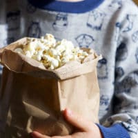 Child Holding Brown Bag of Popcorn