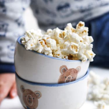 Homemade Popcorn in Bowl with Child Sitting in Background