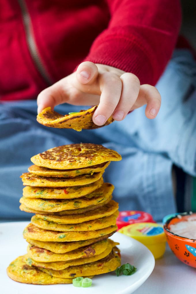 Child Grabbing Chickpea Pancake from a Stack