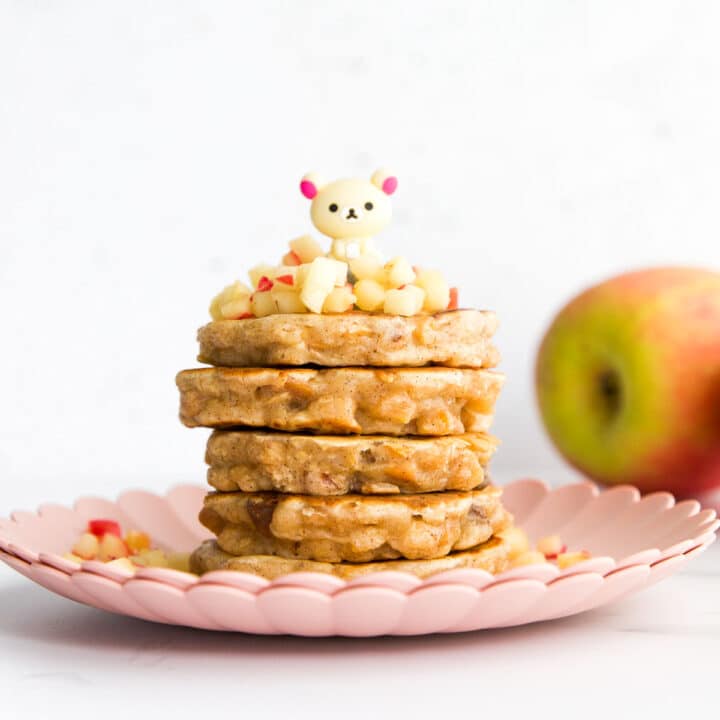 Stack of Apple Pancakes on Plate Topped with Cinnamon Apples.