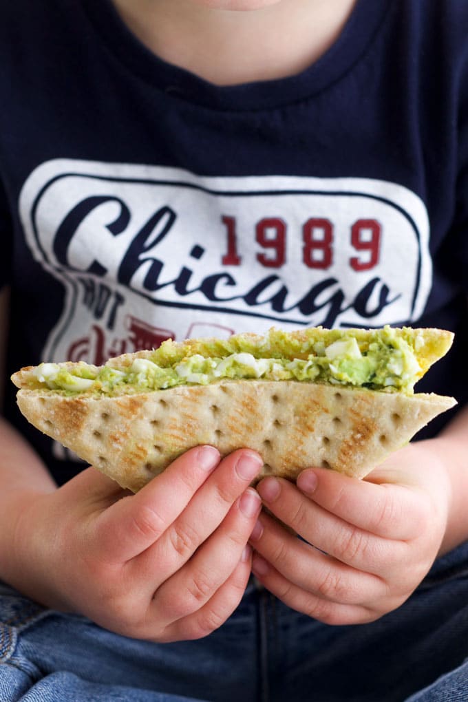 Child Holding Avocado Egg Salad Sandwich