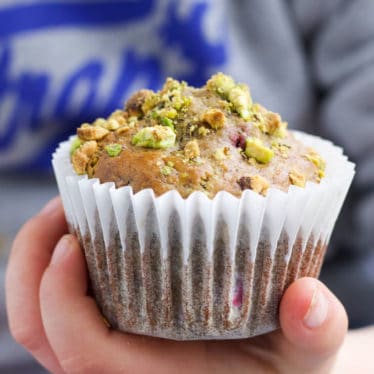 Child Holding a Pistachio and Raspberry Muffin