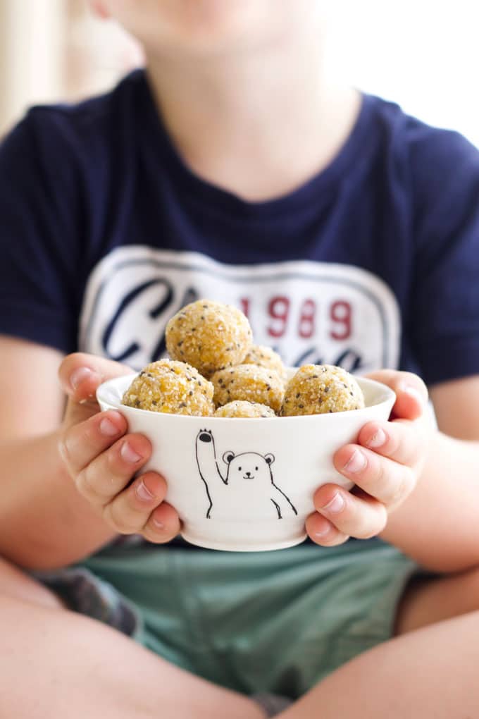 Child Holding Bowl of Apricot Balls