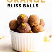 Pinterest Pin with Image of Chocolate Orange Bliss Balls in Bowl with Slices of Orange in Front.