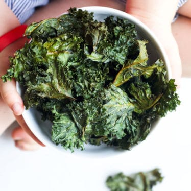 Child Holding a Bowl of Baked Kale Chips