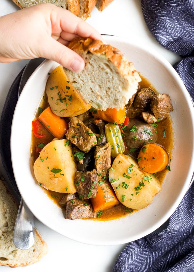Dipping Bread into a Plate of Slow Cooker Beef Stew
