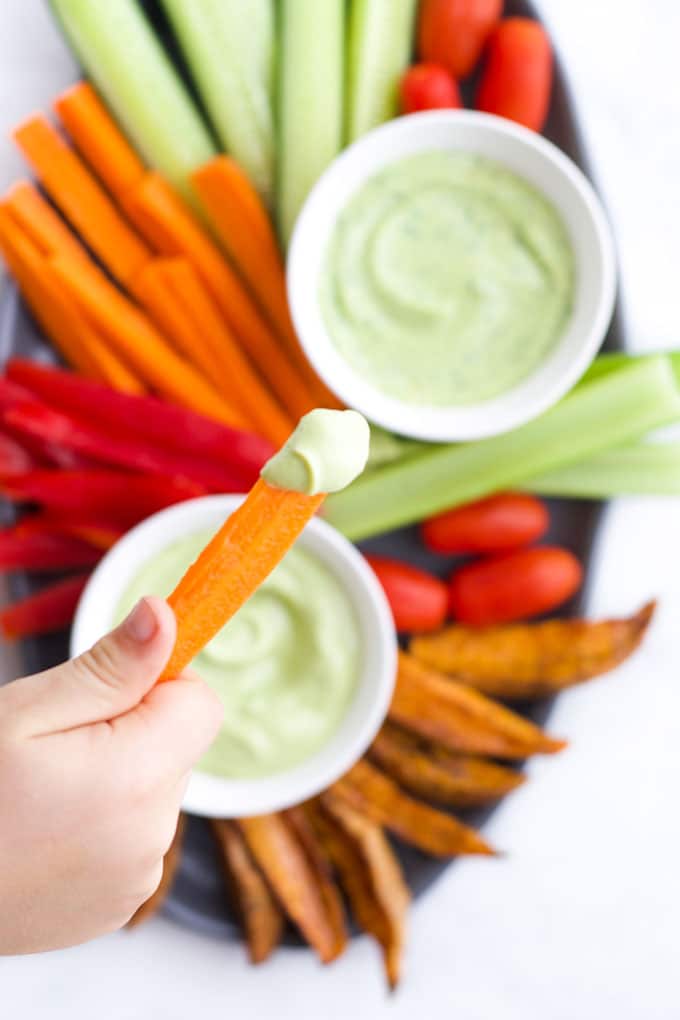 Child Dipping Carrot into Avocado Dip