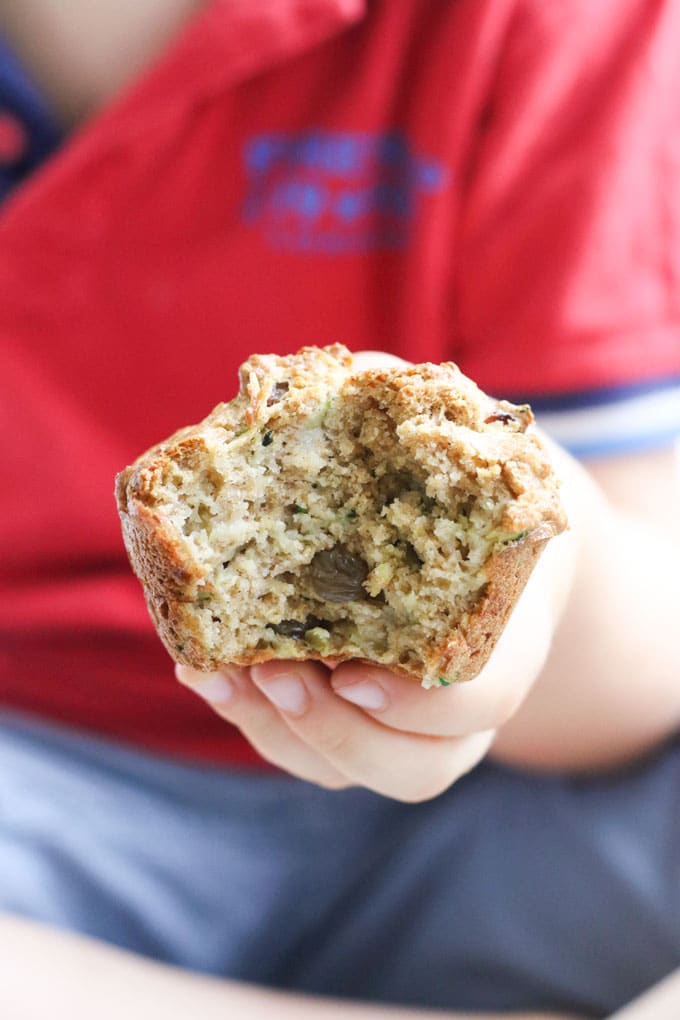 Child Holding a Zucchini Muffin with Bite Out
