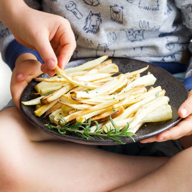 Child Grabbing a Roasted Parsnip from a plate