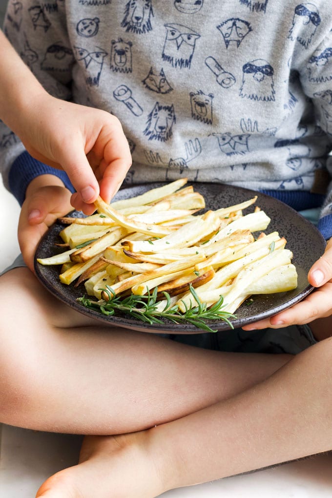 Child Grabbing a Roasted Parsnip from a plate